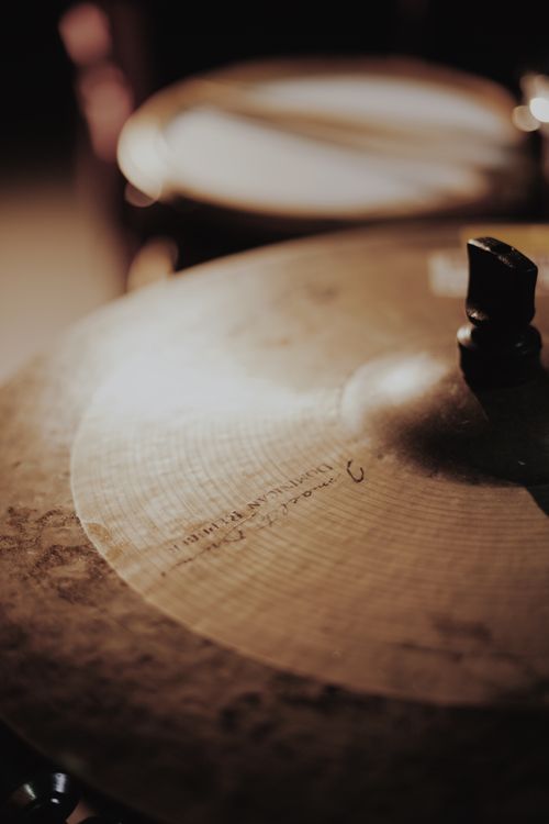 Free Detailed close-up of a cymbal with selective focus in warm lighting. Stock Photo