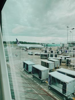 View of airplane at Panama airport terminal with cargo equipment on a cloudy day.