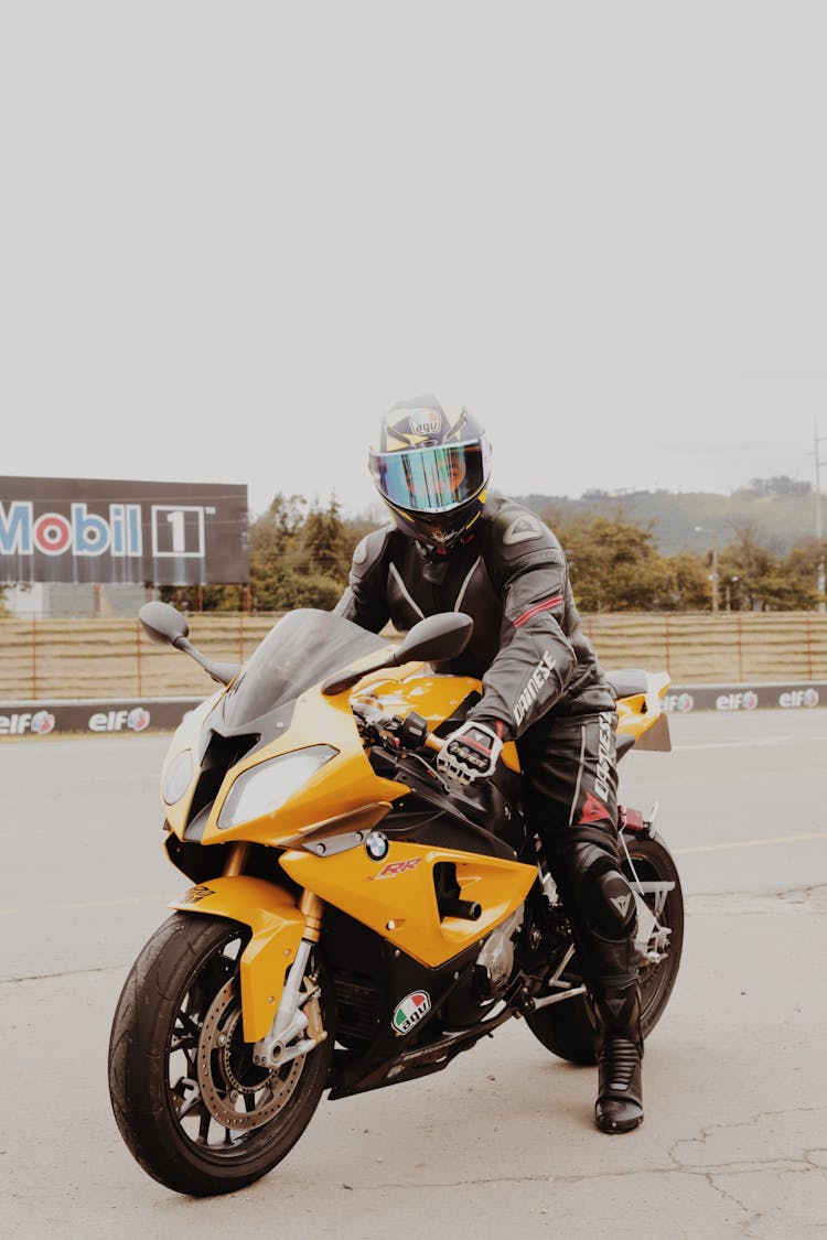 Man Wearing Racing Suit Riding A Sports Bike