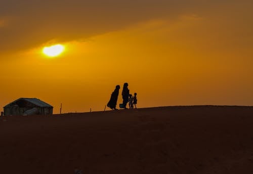 Silhouette of People Walking on the Hill During Golden Hour