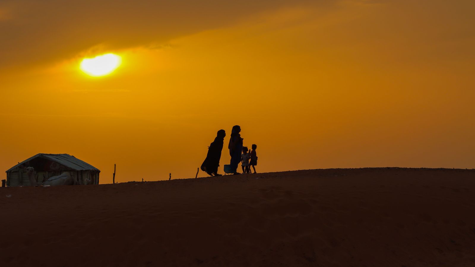 Silhouette of people walking on the hill during golden hour, Mauritania