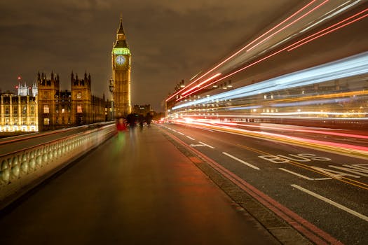 Long exposure of Big Ben and Westminster Bridge with light trails in London at night.