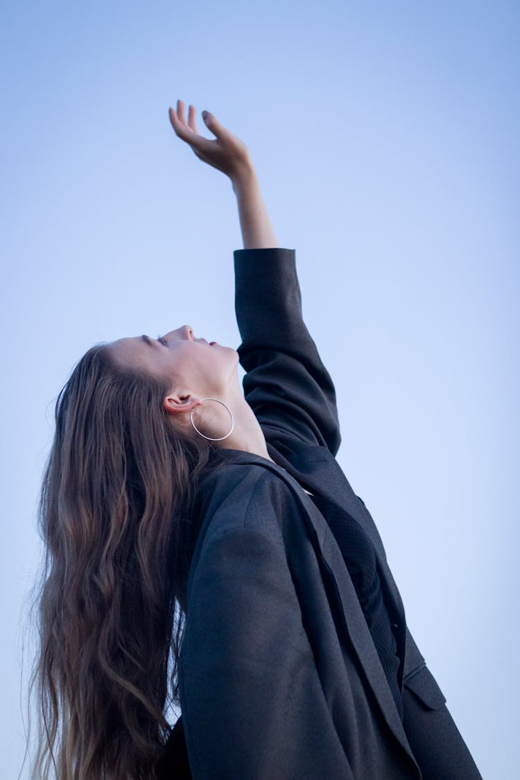 Portrait Of Young Woman Reaching Up