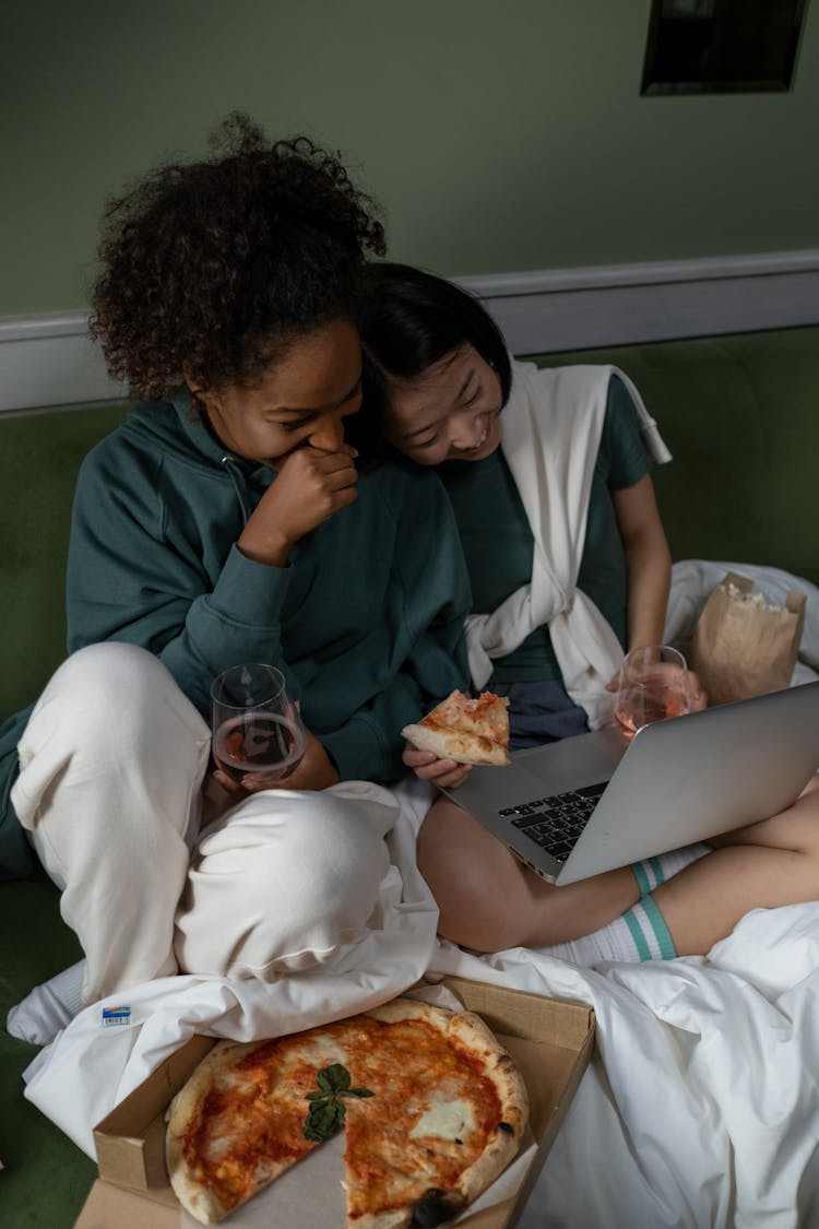 

A Couple Watching On A Laptop While Eating