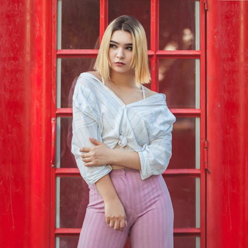 Woman in Stripe Tank Top Standing on Red Door