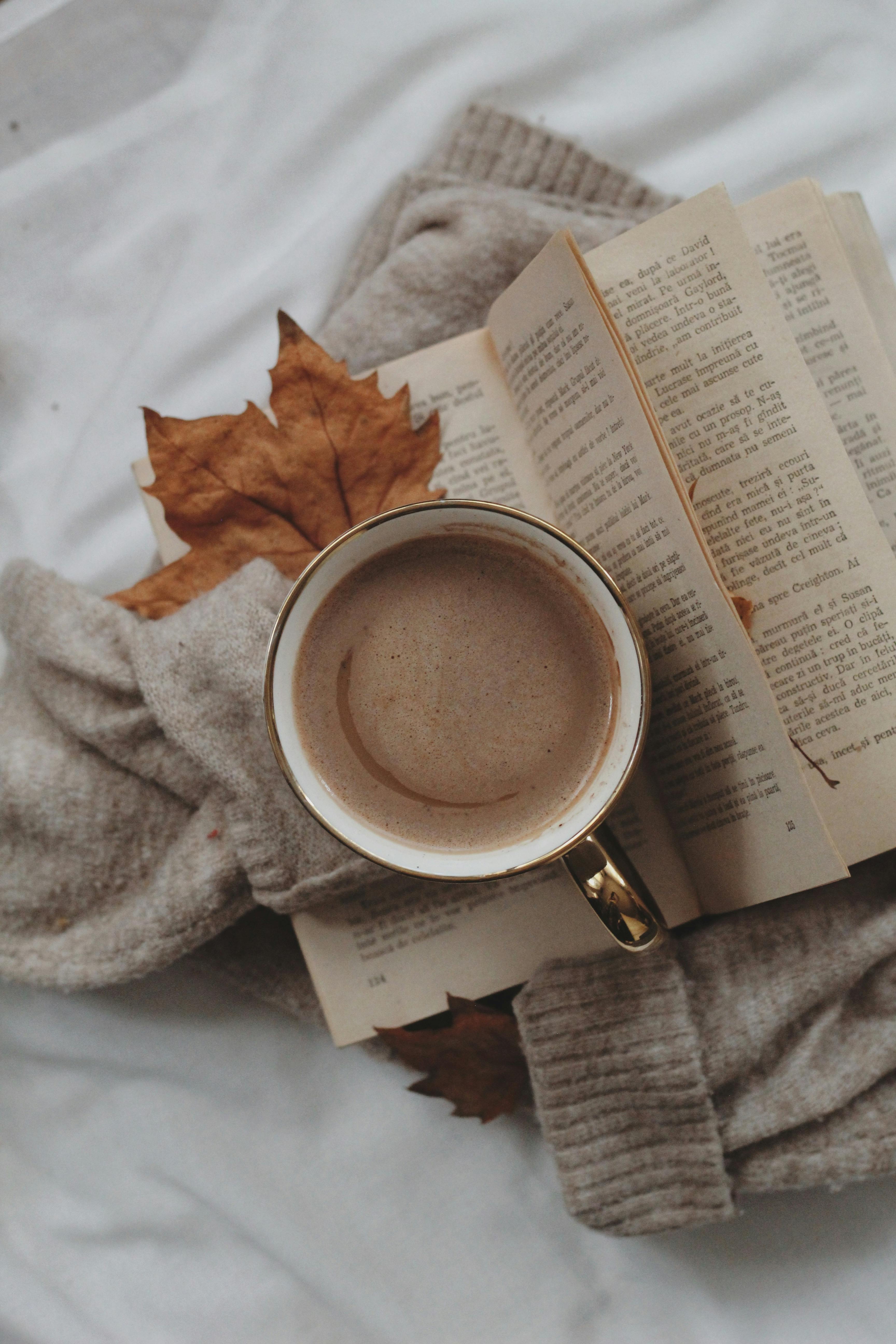 cup of coffee with autumn leaf on book