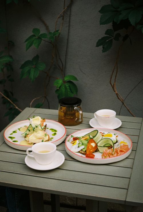 Free Delight in a serene outdoor breakfast featuring fresh vegetables, eggs, and hot tea. Stock Photo