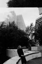 View from Behind Glass of Lonely Woman Sitting on Terrace 