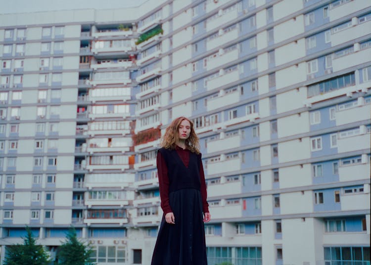 A Woman Standing Outside An Apartment Building