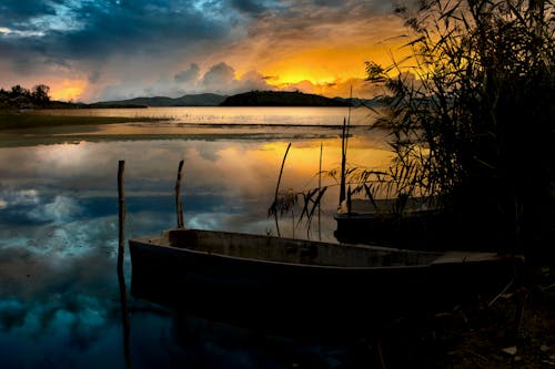 Wooden Boats Docked on the Side of the Lake