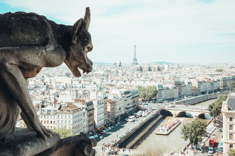 Photo Of A Gargoyle With A View Of A City 