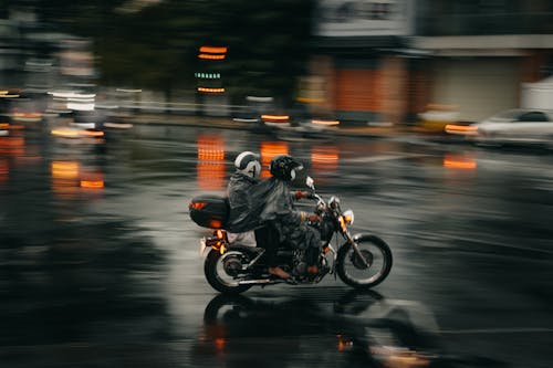 Free People Wearing Raincoats Riding a Motorcycle Stock Photo