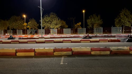 People Riding on Kart Track at Night