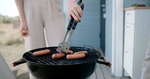A Woman Cooking Sausage
