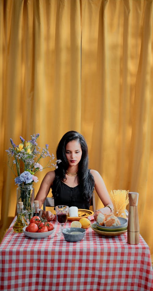 A Woman Banging a Table while Holding a Spoon and a Fork