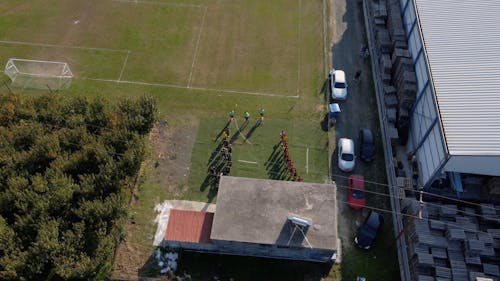 Aerial Footage of a People Walking in the Soccer Field