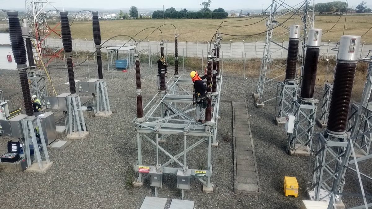 Electricians working on substation equipment