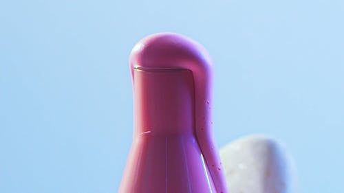 A Pink Liquid Overflowing on a Glass Container