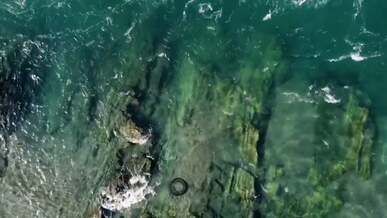 drone footage of water splash in the beach