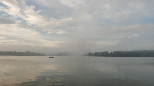 Man in Boat in Lake at Sunrise