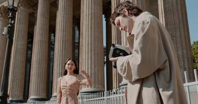 a man filming a woman with a super 8 camera