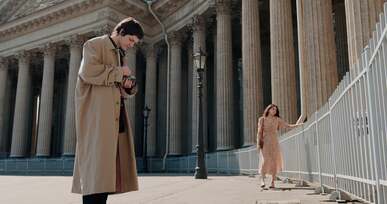 a man walking while filming a woman
