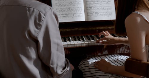 Man Teaching Woman how to Play Piano