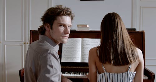 Couple Sitting together by Piano