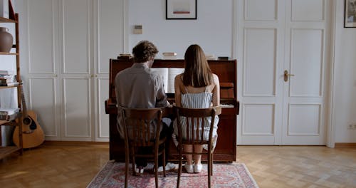 Couple Sitting by Piano and Man Turning Back