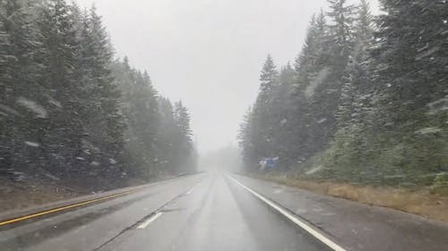 Car Driving on Road During Snowfall