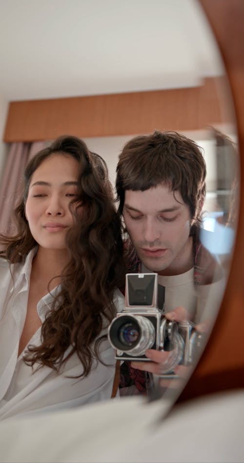 A Couple Taking Photos in front of a Mirror