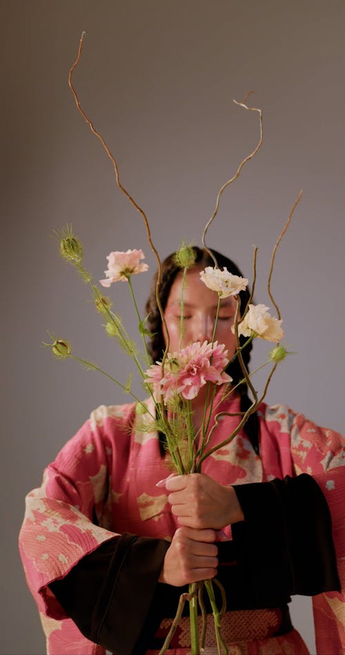 A Woman in a Kimono Holding Flowers