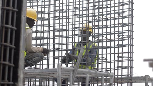 Two Construction Workers Working with Rebars