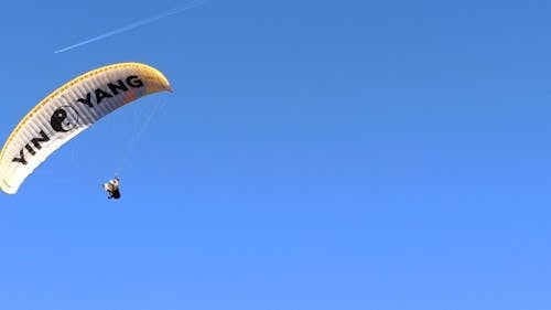 Paraglider Flying Against Blue Sky
