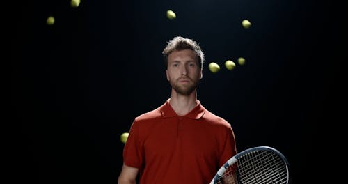 Balls Flying Around Man with Tennis Racket