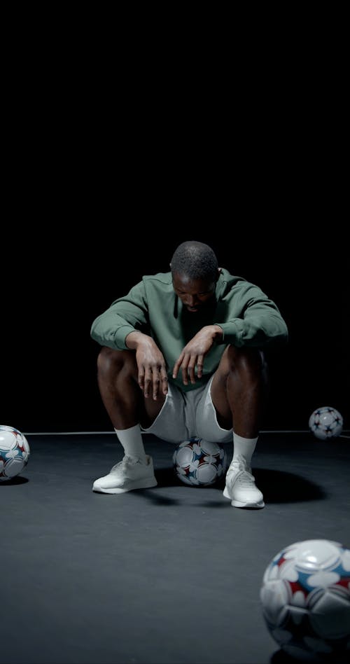 Push in Shot of a Man Sitting on a Soccer Ball