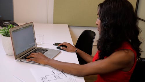 Curly Woman Using her Laptop in the Office