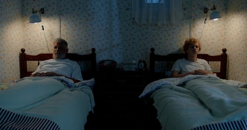 An Elderly Man and his Grandson Going to Sleep in a Bedroom
