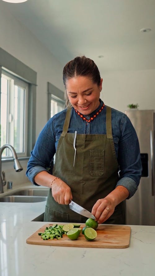 A Woman Slicing a Lime Using Kitchen Knife