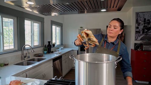 A Woman Taking a Crab out of a Pot