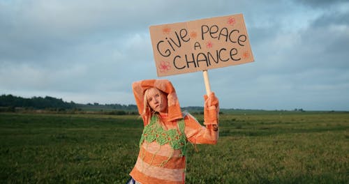 A Woman Holding a Picket Sign in the Countryside