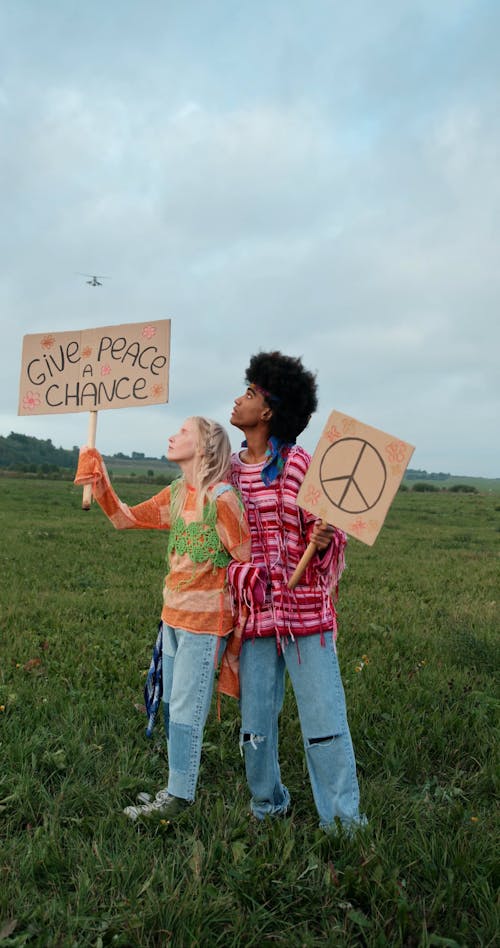 Hippies Holding Cardboard Signs Looking at a Helicopter Passing Overhead