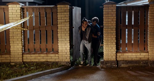 Policeman and Policewoman Taking Criminal to Police Car