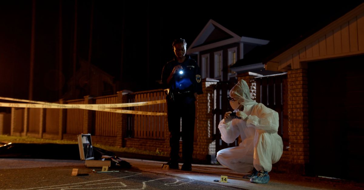 Officers Checking Scene Police Officer and Technician Inspecting Evidence next to Buildings ...