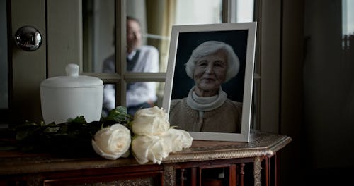 White Roses next to a Picture of a Lady