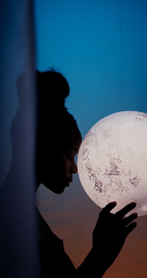 Side View of a Woman Holding a Moon Pendant Lamp 