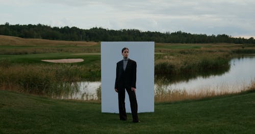 Woman Standing in Front of Wall by Pond