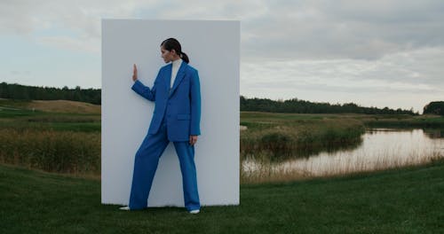 Woman Moving Arms by Wall on Grass