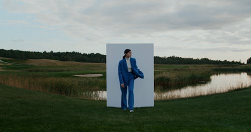 Woman in Suit Walking from Wall by Pond