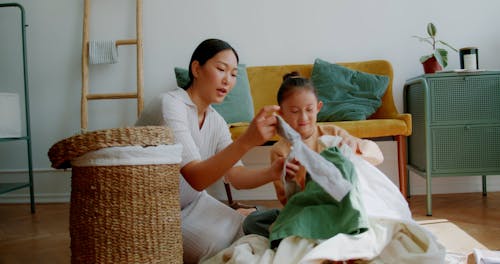 A Woman Sorting Laundry with her Daughter